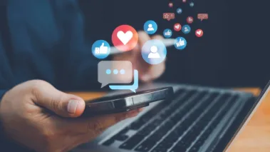 Person uses phone as social media icons float out of it